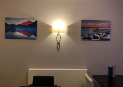 A bar table with photo canvases of criccieth beach and snowdonia.