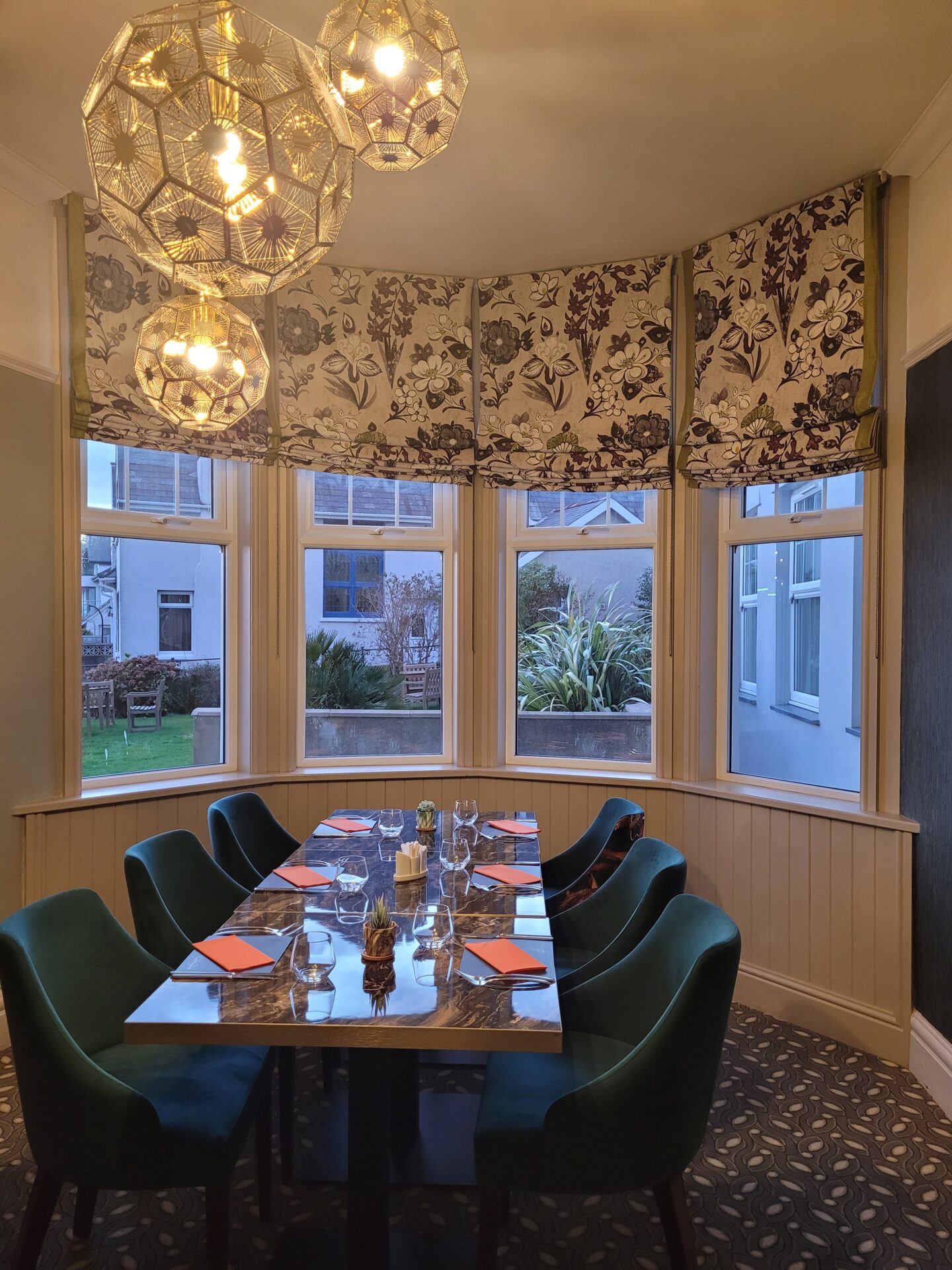 A restaurant dining table with a bay window view.